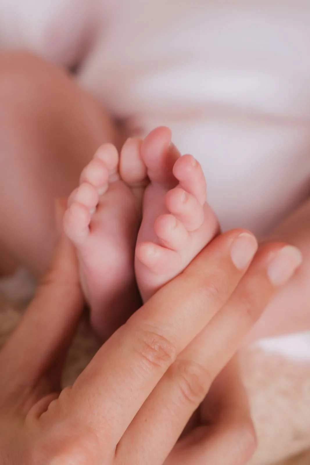 Pies de bebé recién nacido en la mano de su mamá, sesión de recién nacido en Villaviciosa de Odón